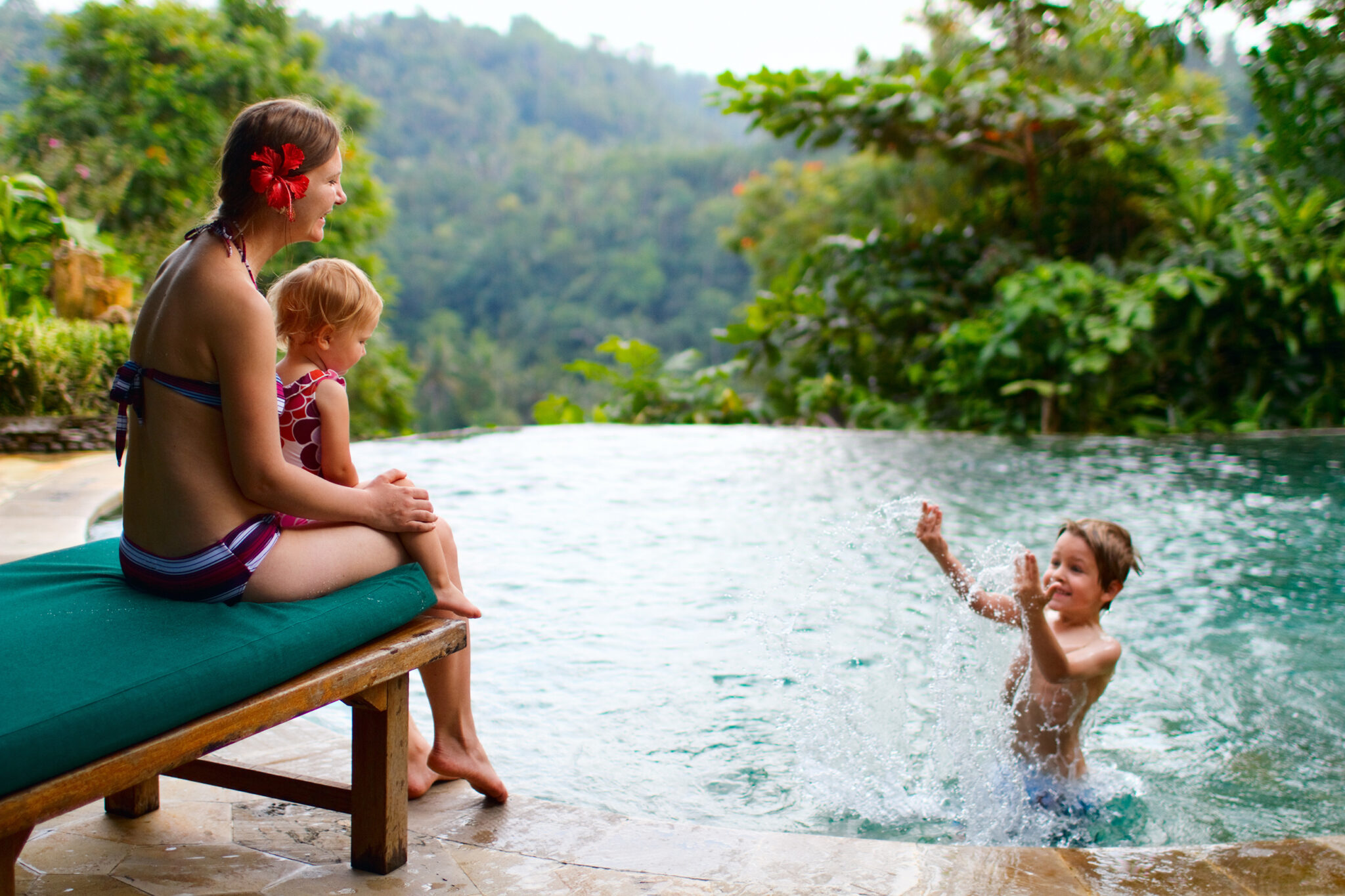 Mães e filhos na piscina do hotel em viagem em família